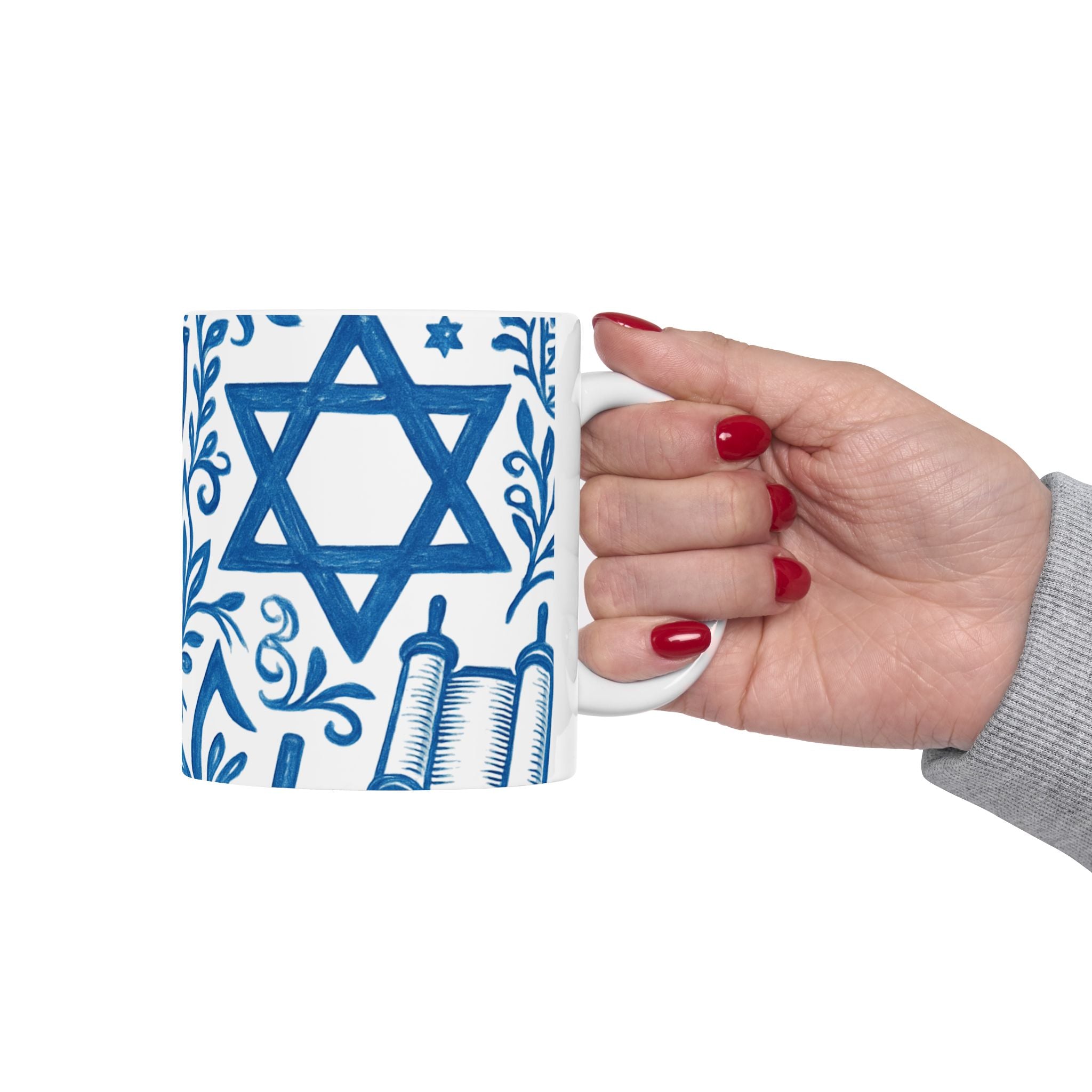 Hand holding a mug with Star of David and Torah design on a white background
