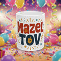 White mug with colorful 'Mazel Tov' text on a white background
