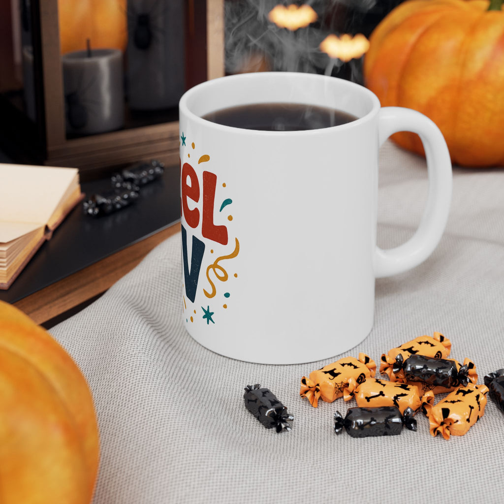 White mug with colorful text, steaming hot chocolate, Halloween-themed cookies, and pumpkins on a table.