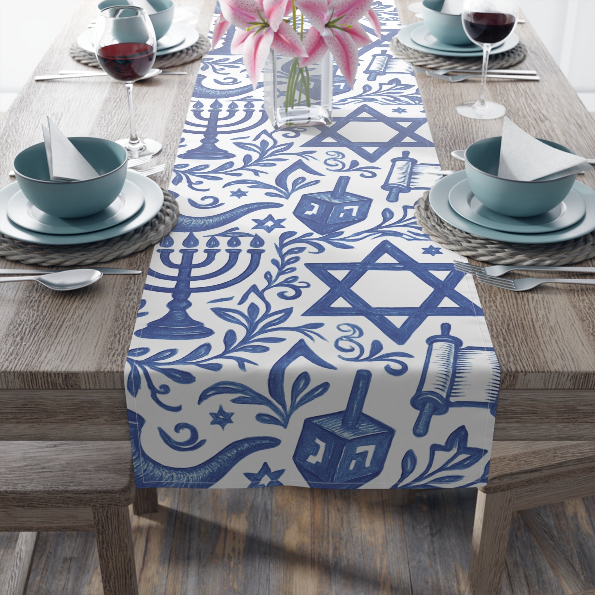 Table setting with a blue and white Hanukkah-themed table runner on a wooden table.