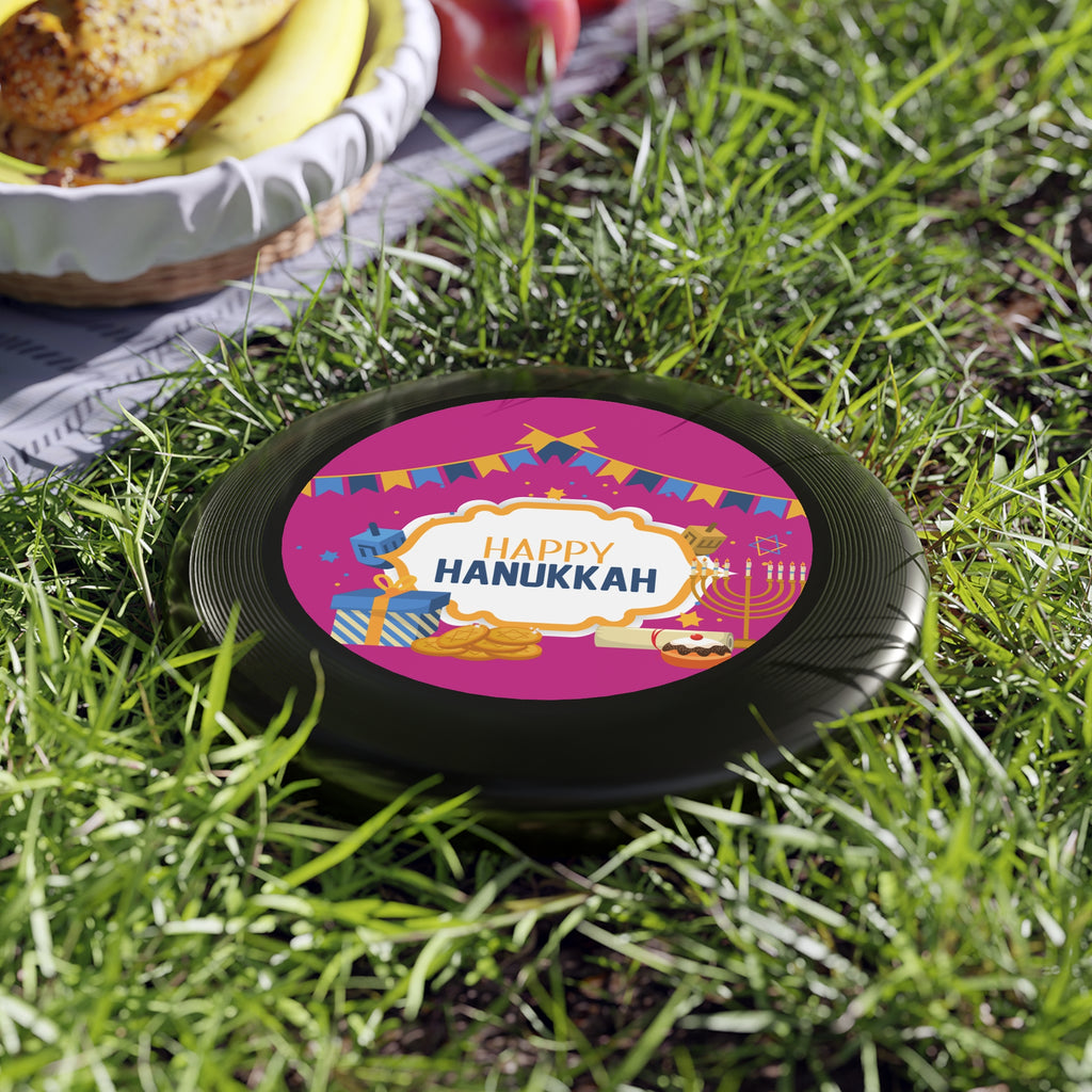 Happy Hanukkah-themed trivet on grass with a bowl of food in the background